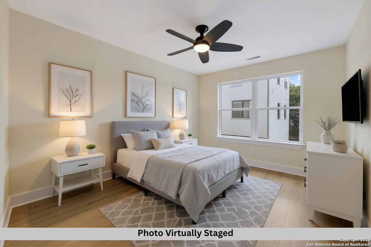 11710 Vance Jackson Road, Unit 702 San Antonio, TX 78230 - Photo 7 of 25 a bedroom with a bed window and a flat screen tv