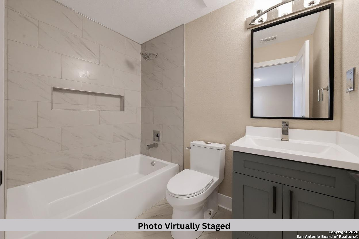 11710 Vance Jackson Road, Unit 702 San Antonio, TX 78230 - Photo 8 of 25 a bathroom with a sink a toilet and a mirror