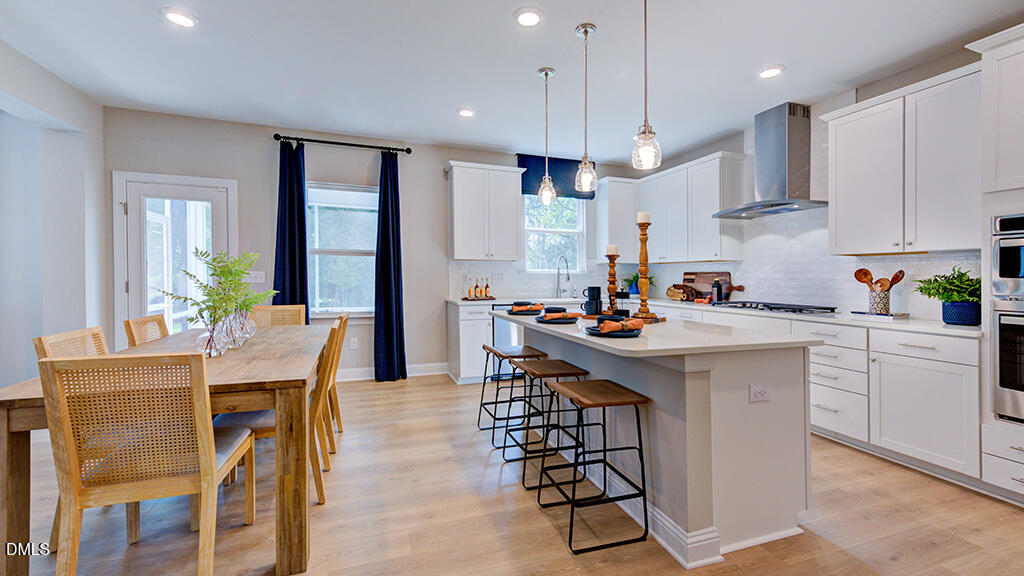 222 Tidal Pool Way Cary, NC 27519 - Photo 11 of 25 a kitchen with stainless steel appliances kitchen island granite countertop a table chairs sink and cabinets
