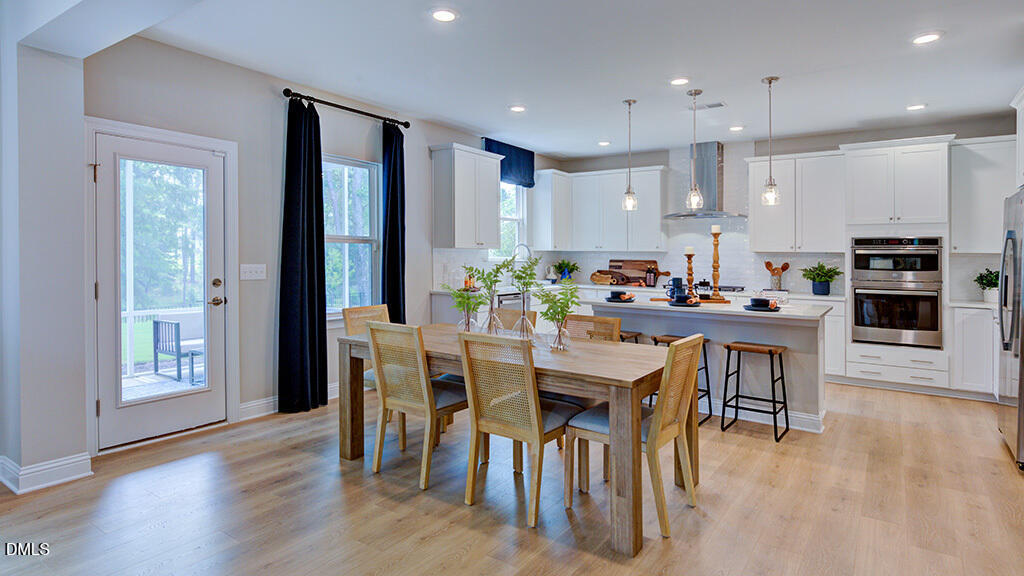 222 Tidal Pool Way Cary, NC 27519 - Photo 8 of 25 a kitchen with kitchen island granite countertop wooden floor cabinets and stainless steel appliances