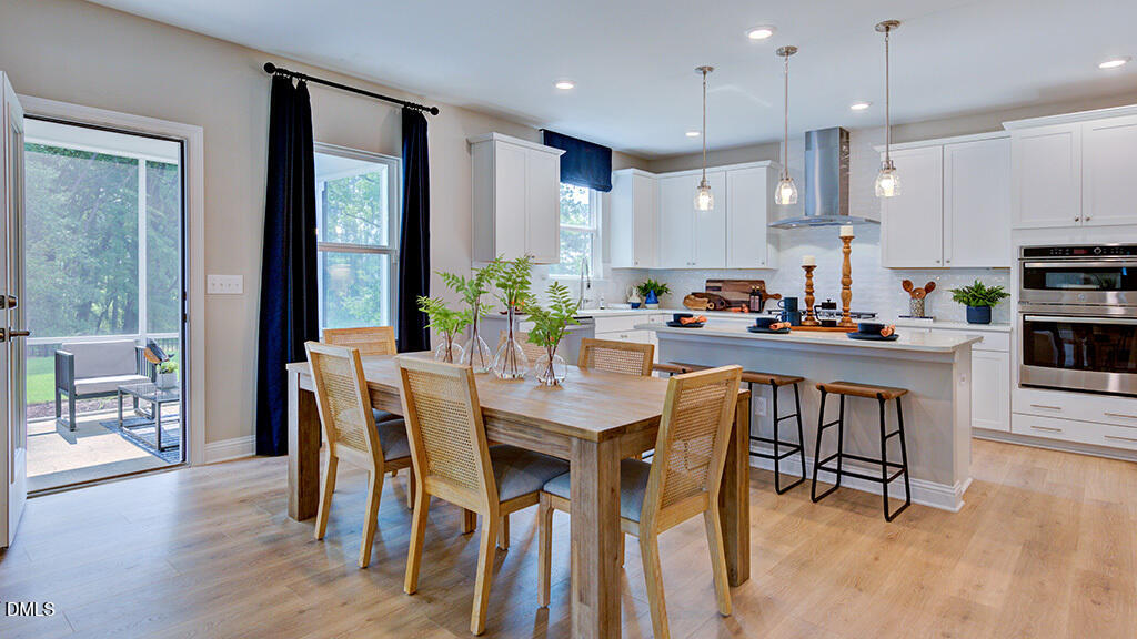 222 Tidal Pool Way Cary, NC 27519 - Photo 9 of 25 a kitchen with stainless steel appliances kitchen island granite countertop a dining table chairs and granite counter tops