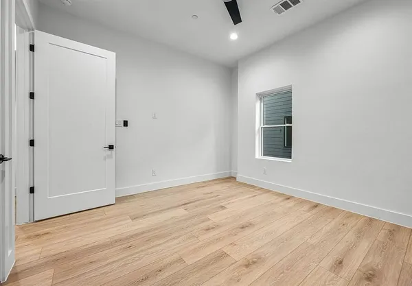 a view of an empty room with wooden floor