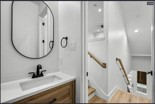 a bathroom with a sink a mirror a vanity and shower