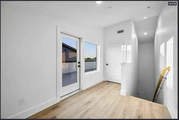 wooden floor in an empty room with a bathroom