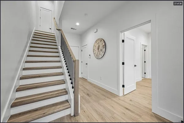 a view of a hallway with wooden floor and windows