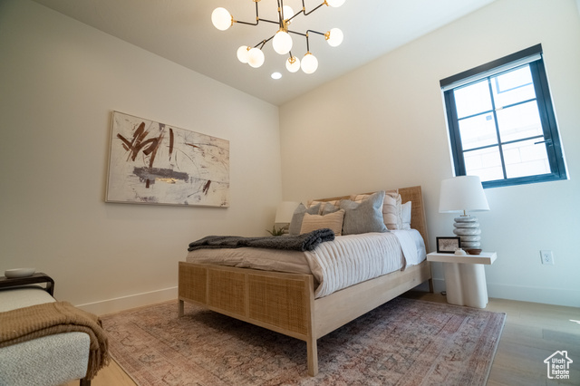 5366 Cyan Lane St. George, UT 84790 - Photo 21 of 39 Bedroom featuring wood finished floors and a chandelier