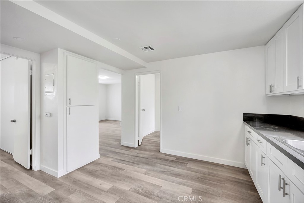 1813 West Ball Road Anaheim, CA 92804 - Photo 12 of 36 a view of a kitchen with white cabinets and wooden floor