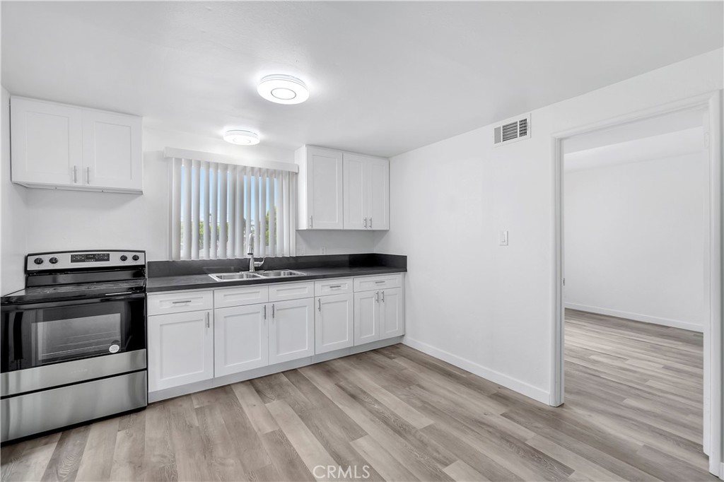 1813 West Ball Road Anaheim, CA 92804 - Photo 22 of 36 a kitchen with granite countertop white cabinets and white appliances