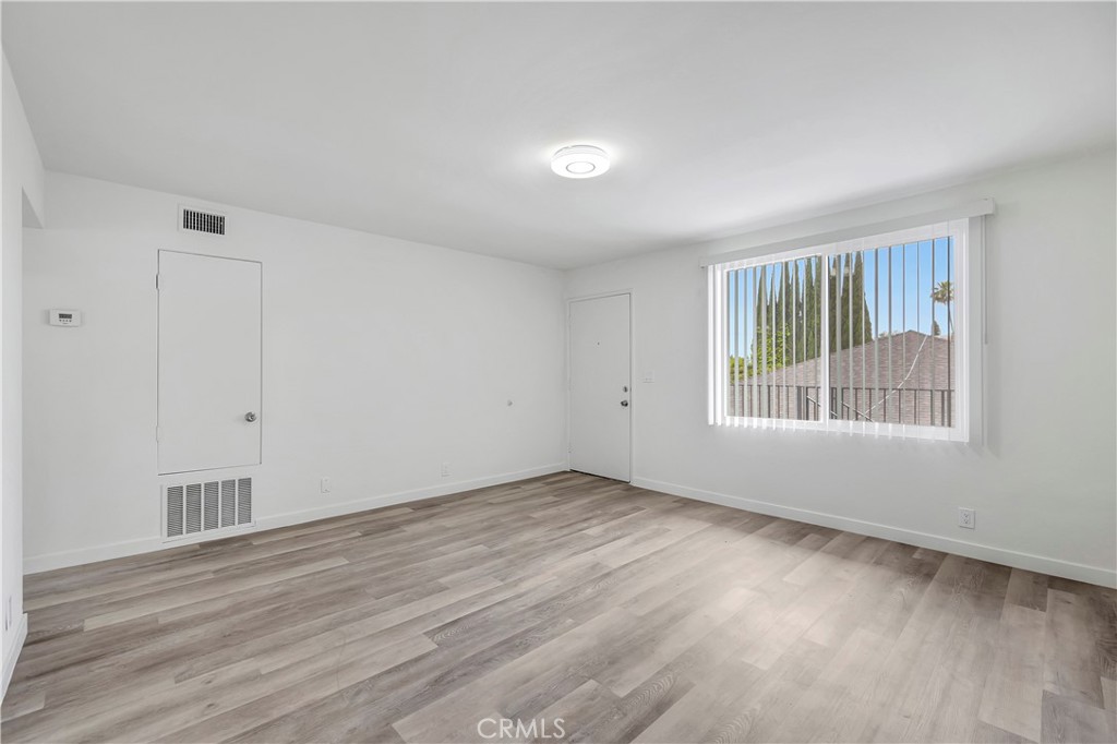 1813 West Ball Road Anaheim, CA 92804 - Photo 9 of 36 a view of an empty room with wooden floor and a window