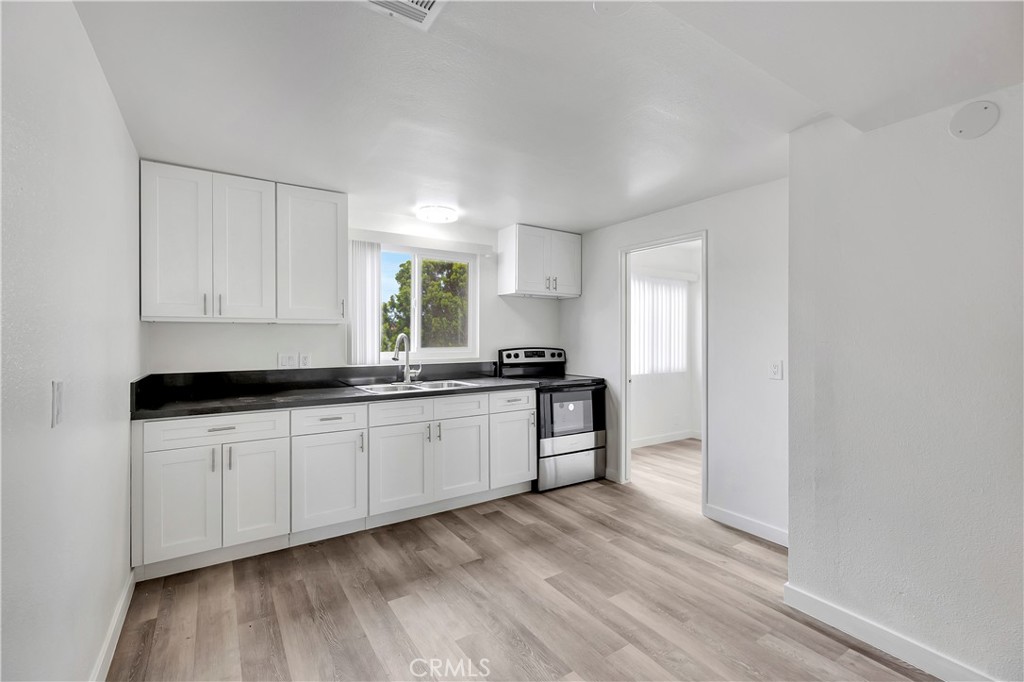 1813 West Ball Road Anaheim, CA 92804 - Photo 10 of 36 a kitchen with granite countertop a sink and a stove top oven