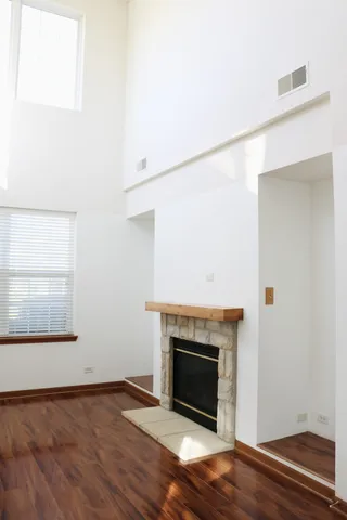 a view of a livingroom with wooden floor and a fireplace