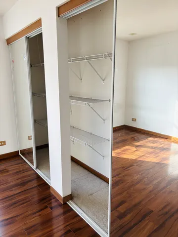 an empty room with wooden floor and white walls