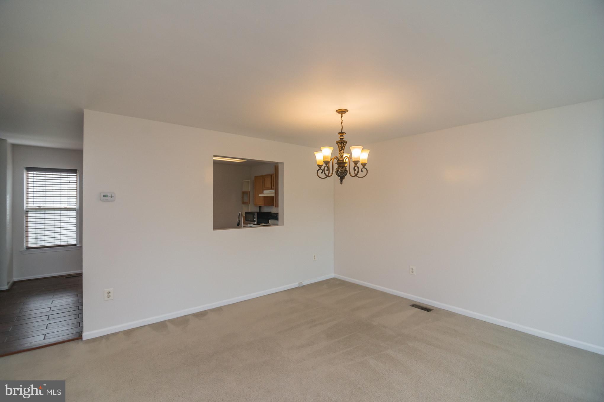 7311 Gateside Place Springfield, VA 22150 - Photo 19 of 30 an empty room with a chandelier fan and windows