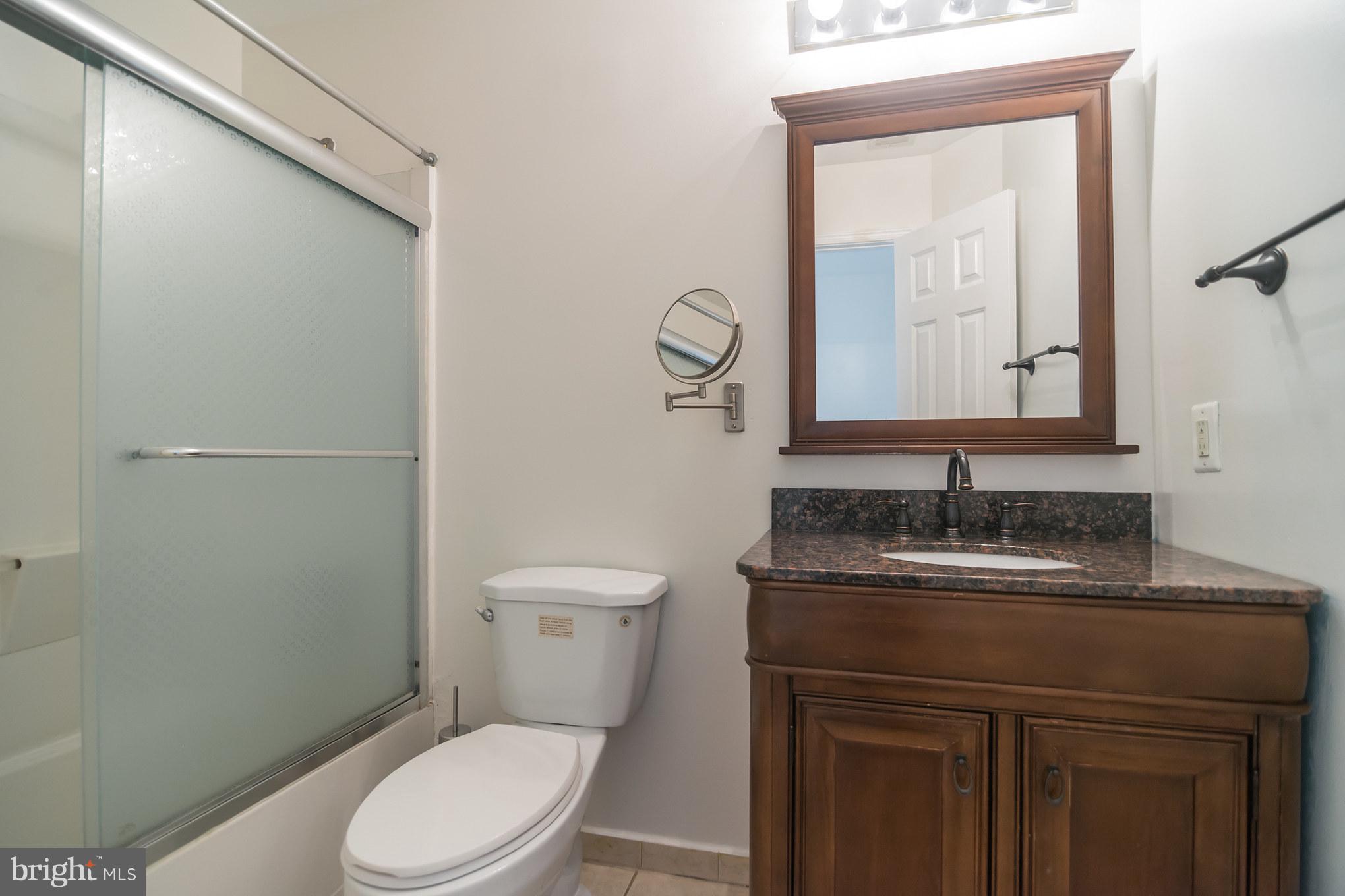 7311 Gateside Place Springfield, VA 22150 - Photo 27 of 30 a bathroom with a granite countertop toilet a sink and a mirror