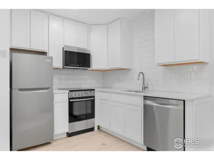 a kitchen with a refrigerator sink and cabinets