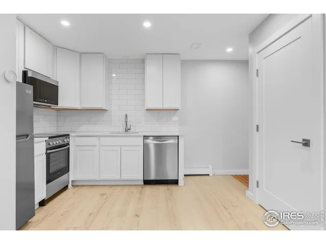 a view of a kitchen with a sink and a refrigerator