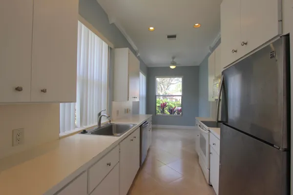 a kitchen with stainless steel appliances granite countertop a refrigerator and a sink