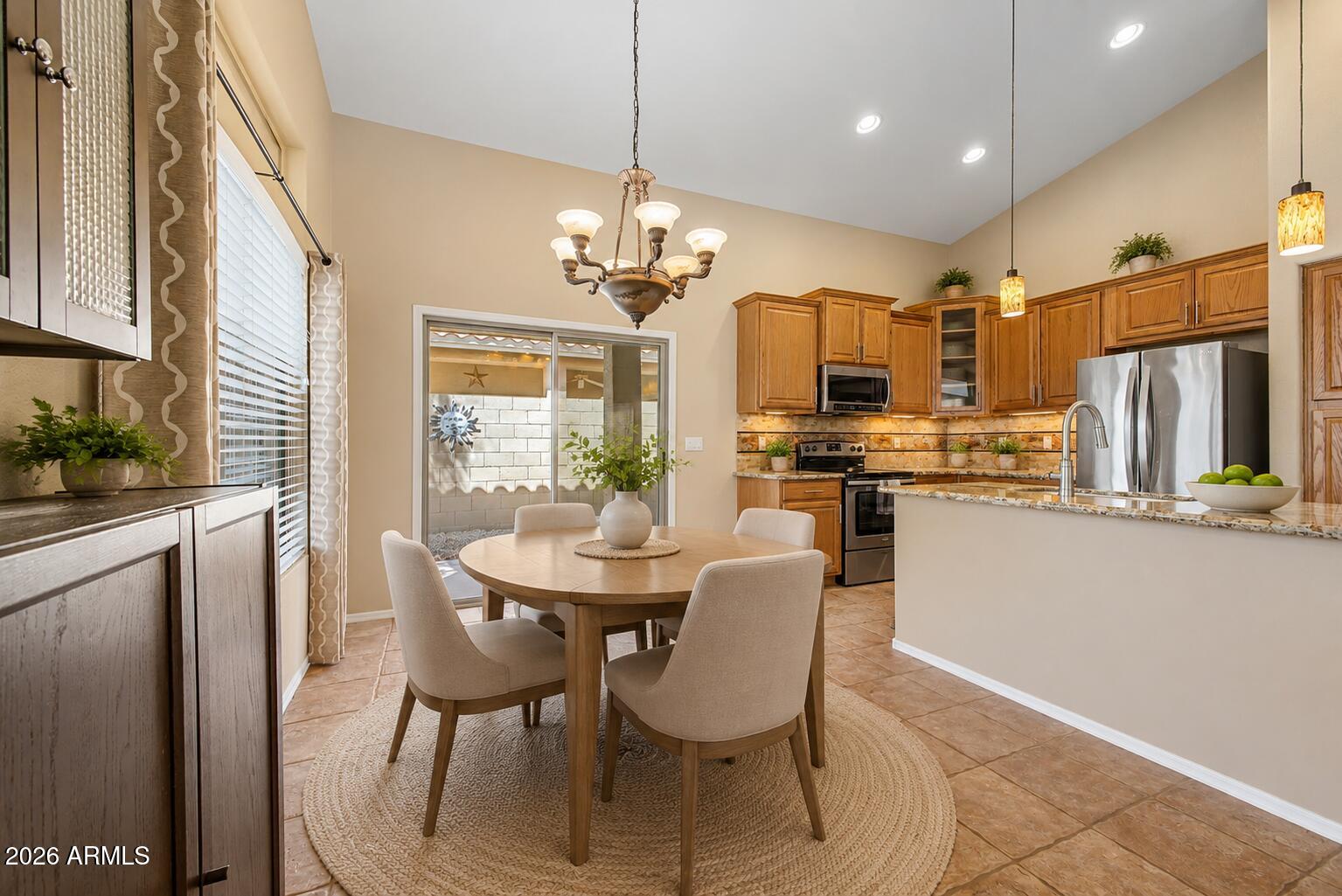 40602 North Apollo Way Anthem, AZ 85086 - Photo 16 of 38 a view of a dining room with furniture a chandelier and kitchen view