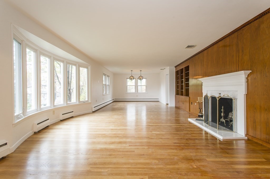150 Buckminster Road Brookline, MA 02445 - Photo 7 of 25 a view of an empty room with window and wooden floor