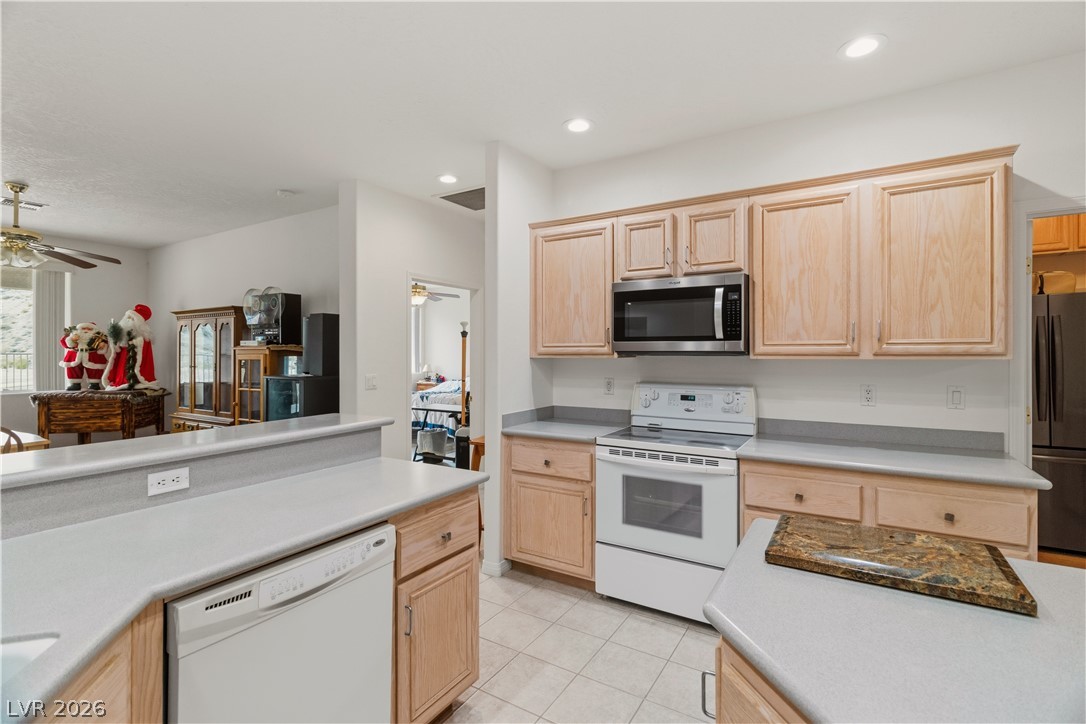 3589 Cottage Canyon Street Laughlin, NV 89029 - Photo 11 of 99 Kitchen with light wood finish cabinetry, white appliances, light countertops, ceiling fan, and recessed lighting