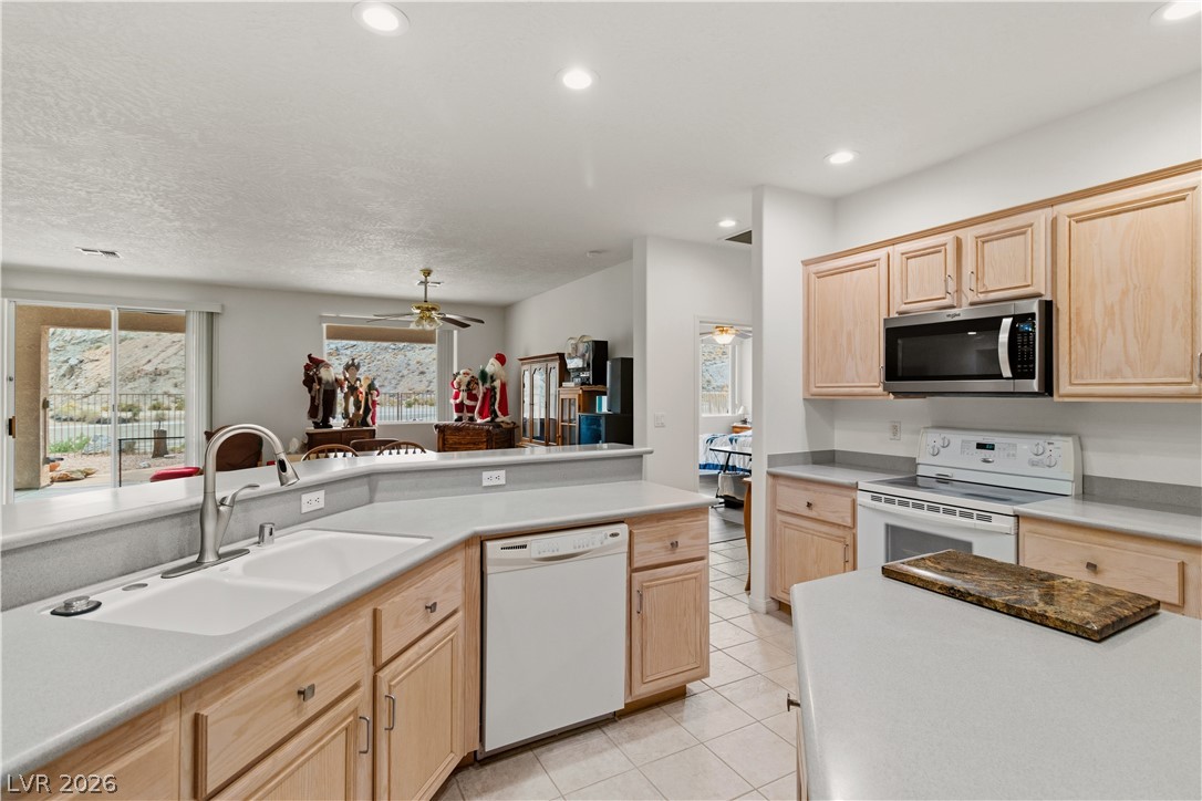 3589 Cottage Canyon Street Laughlin, NV 89029 - Photo 12 of 99 Kitchen with light wood finish cabinets, white appliances, light countertops, and recessed lighting