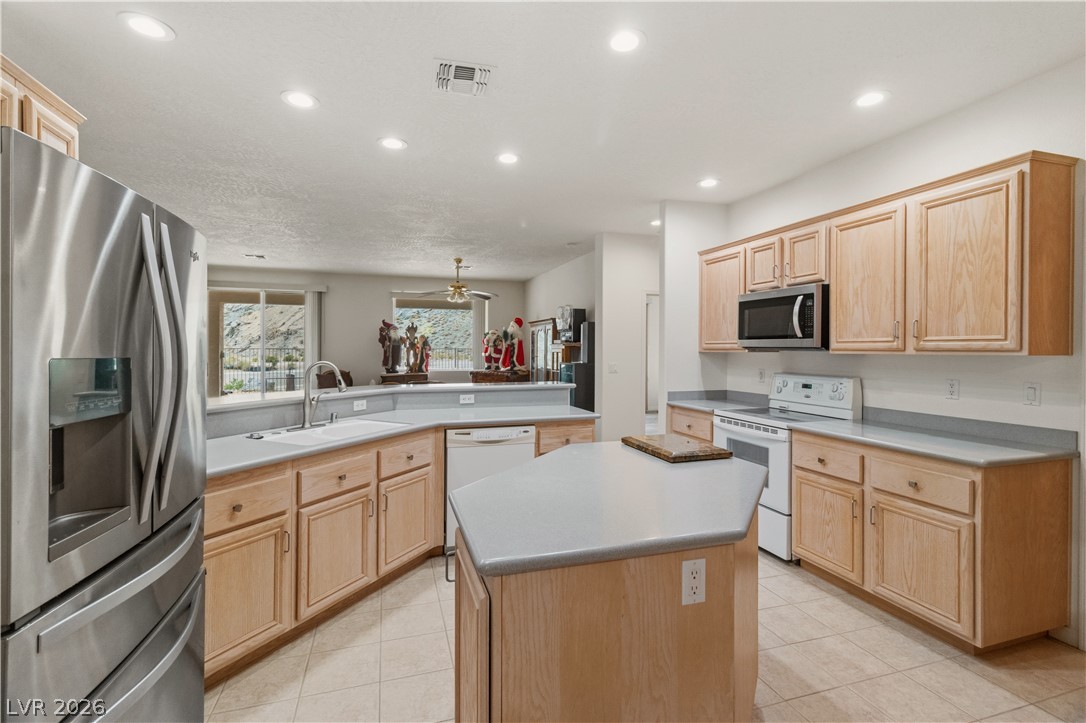 3589 Cottage Canyon Street Laughlin, NV 89029 - Photo 13 of 99 Kitchen with stainless steel appliances, light wood finish cabinets, light countertops, a peninsula, and recessed lighting