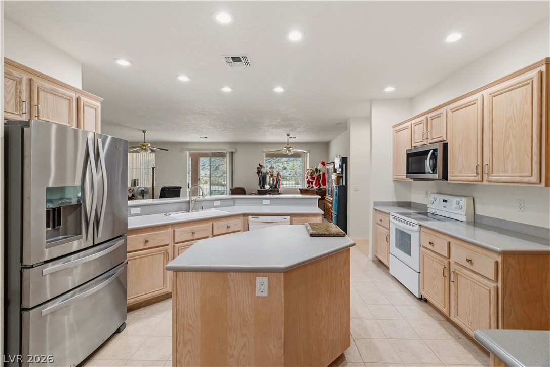 3589 Cottage Canyon Street Laughlin, NV 89029 - Photo 14 of 99 Kitchen with stainless steel appliances, light wood finish cabinets, light countertops, a center island, and recessed lighting