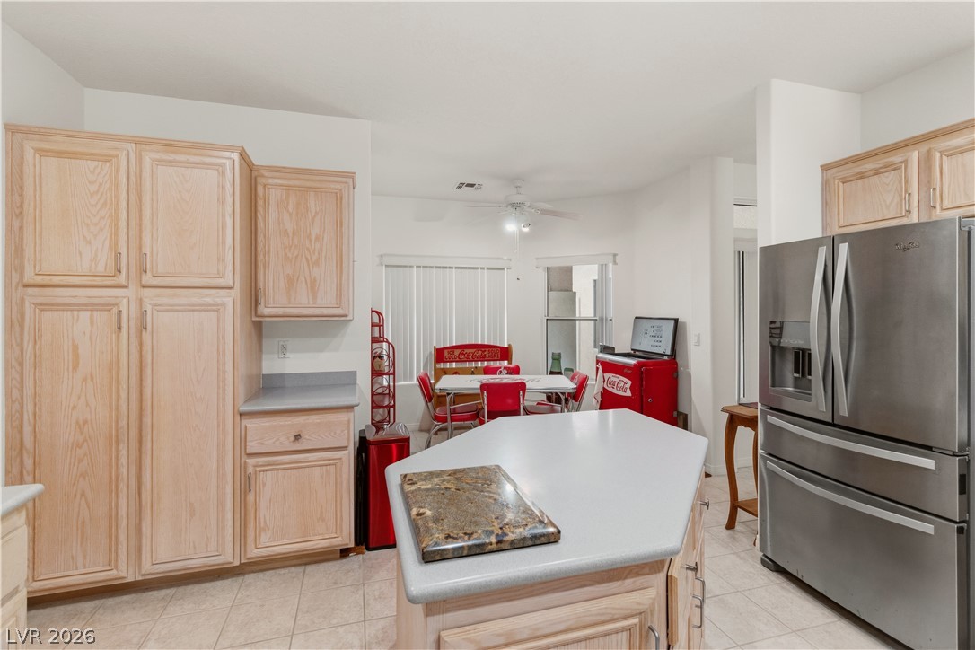 3589 Cottage Canyon Street Laughlin, NV 89029 - Photo 15 of 99 Kitchen with light wood finish cabinetry, stainless steel refrigerator with ice dispenser, a center island, and light countertops