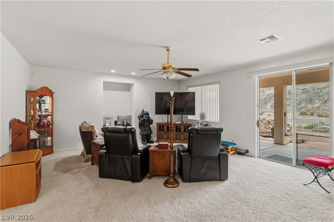 3589 Cottage Canyon Street Laughlin, NV 89029 - Photo 19 of 99 Carpeted living area featuring a ceiling fan, recessed lighting, and a textured ceiling
