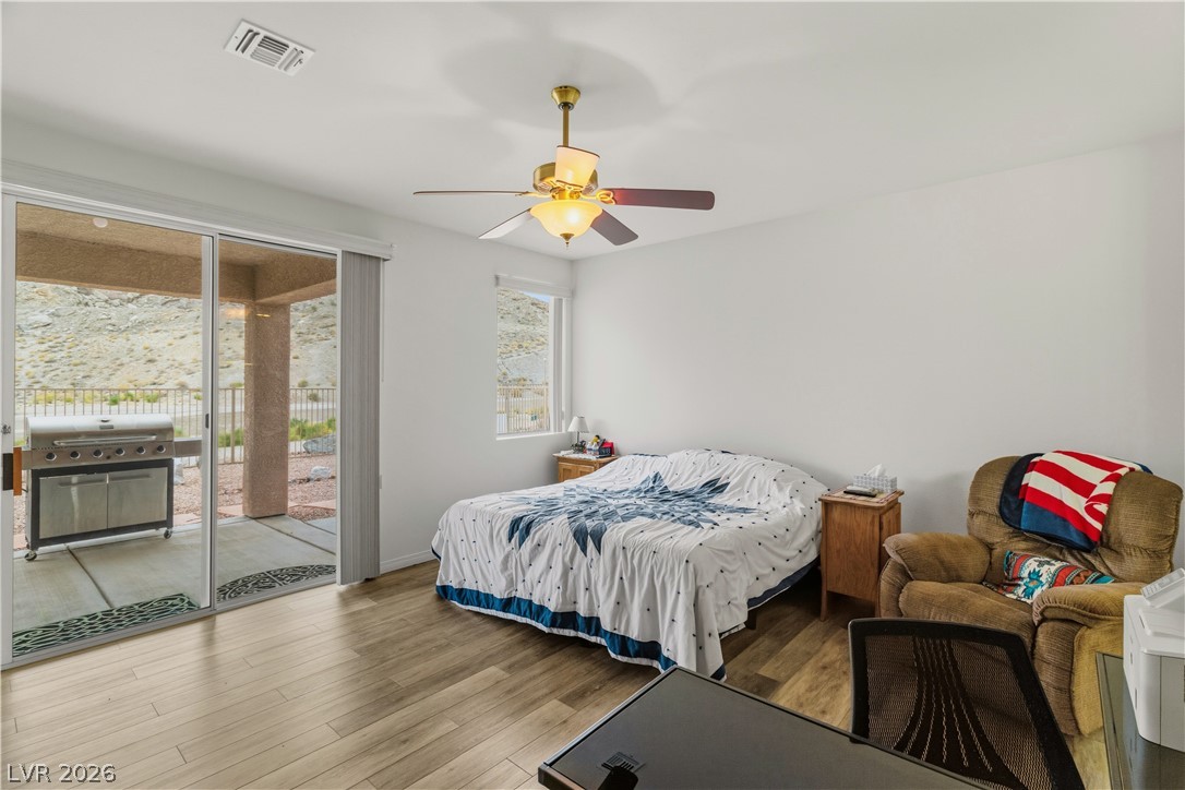 3589 Cottage Canyon Street Laughlin, NV 89029 - Photo 27 of 99 Primary Bedroom featuring wood finished floors, access to outside, and ceiling fan