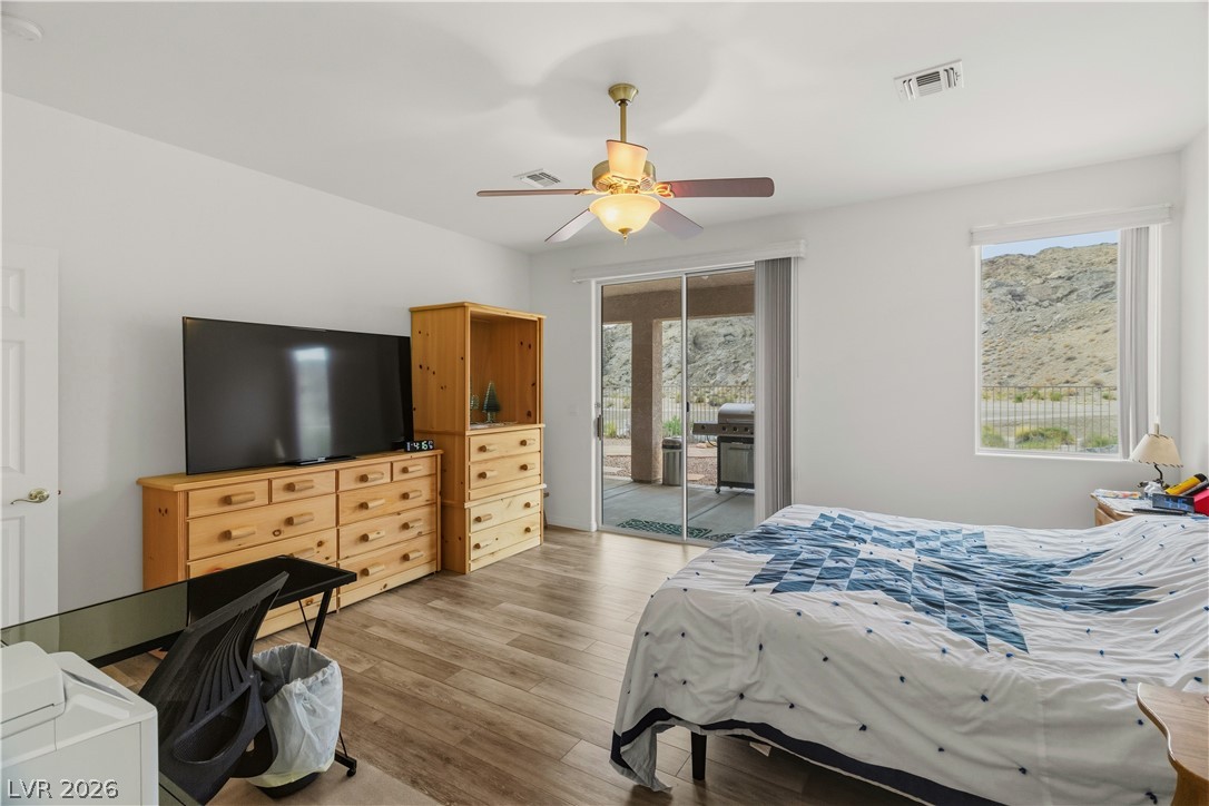 3589 Cottage Canyon Street Laughlin, NV 89029 - Photo 28 of 99 Primary Bedroom featuring wood finished floors, access to outside, and ceiling fan