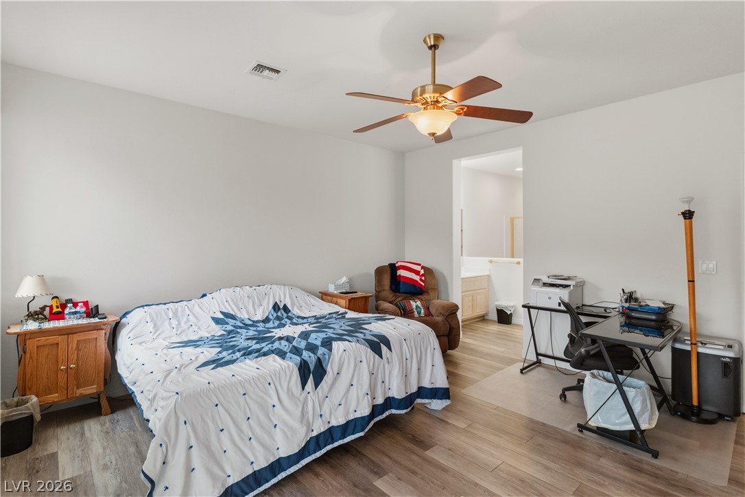 3589 Cottage Canyon Street Laughlin, NV 89029 - Photo 29 of 99 Primary Bedroom featuring a desk, light wood-type flooring, a ceiling fan, and ensuite bath