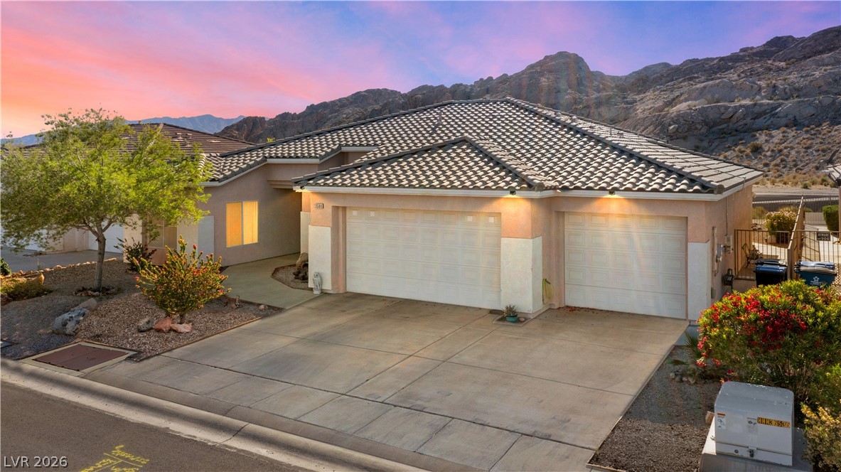 3589 Cottage Canyon Street Laughlin, NV 89029 - Photo 3 of 99 View of front facade featuring a garage, stucco siding, concrete driveway, a mountain view, and a tiled roof