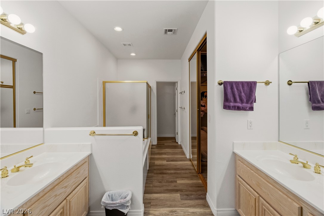 3589 Cottage Canyon Street Laughlin, NV 89029 - Photo 31 of 99 Full Ensuite Primary bathroom with two vanities, a stall shower, dark wood finished floors, a walk in closet, and recessed lighting