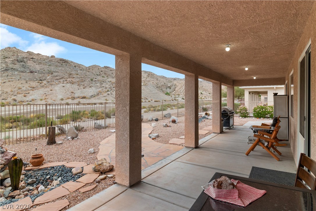 3589 Cottage Canyon Street Laughlin, NV 89029 - Photo 60 of 99 Covered porch with a mountain view, a fenced backyard, and grilling area