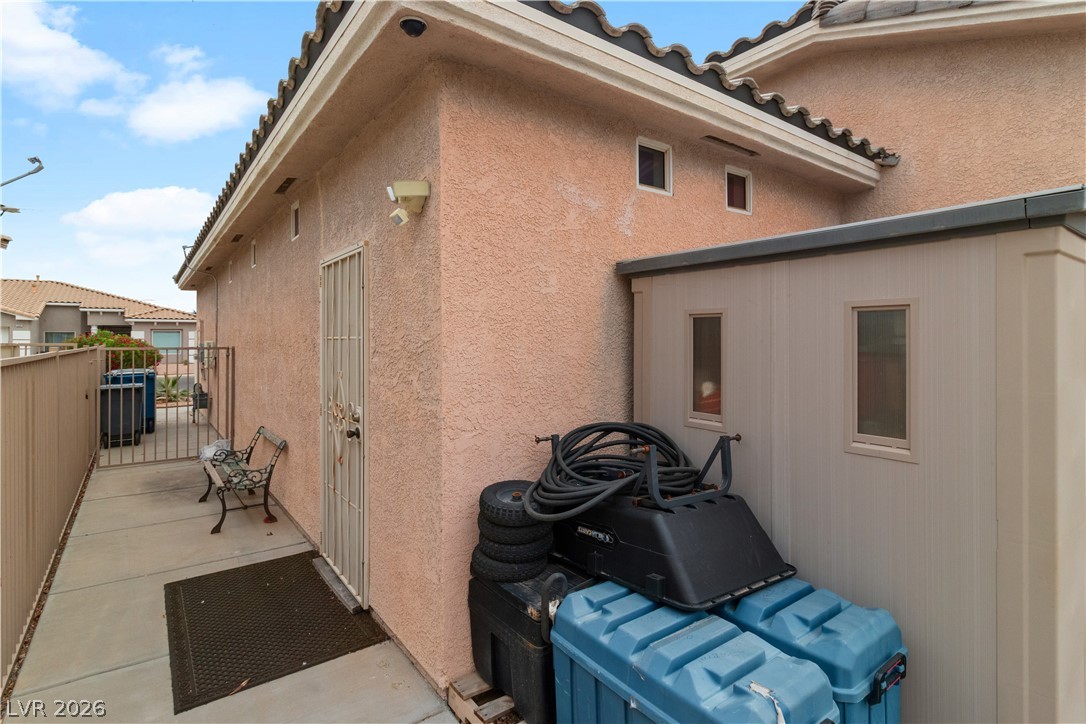 3589 Cottage Canyon Street Laughlin, NV 89029 - Photo 67 of 99 View of side of home featuring stucco siding, a tiled roof, and a gate