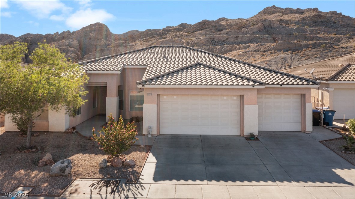 3589 Cottage Canyon Street Laughlin, NV 89029 - Photo 81 of 99 View of front facade with a garage, concrete driveway, and stucco siding