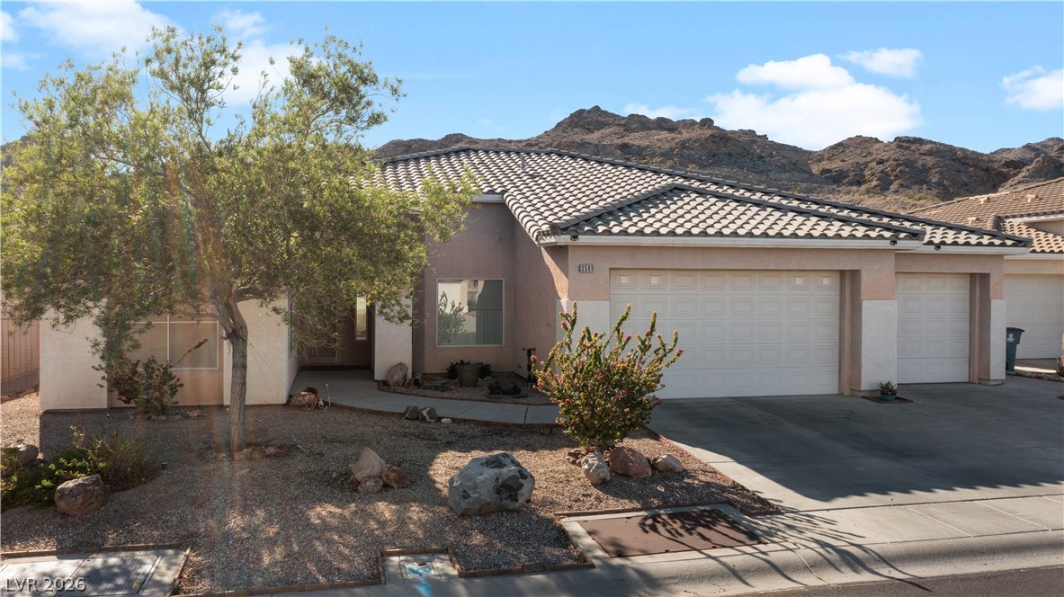 3589 Cottage Canyon Street Laughlin, NV 89029 - Photo 82 of 99 View of front of house featuring stucco siding, a garage, concrete driveway, and a tiled roof