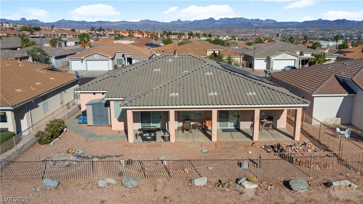 3589 Cottage Canyon Street Laughlin, NV 89029 - Photo 84 of 99 Rear view of house featuring a patio, a tile roof, a residential view, a fenced backyard, and a mountain view