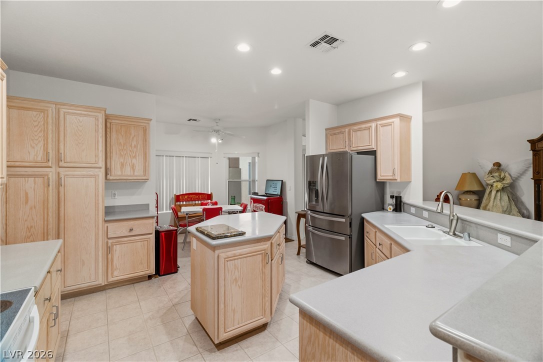 3589 Cottage Canyon Street Laughlin, NV 89029 - Photo 9 of 99 Kitchen with light wood finish cabinetry, a center island, electric stove, recessed lighting, and stainless steel fridge with ice dispenser