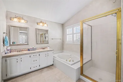 a spacious bathroom with a double vanity sink a mirror and a bathtub