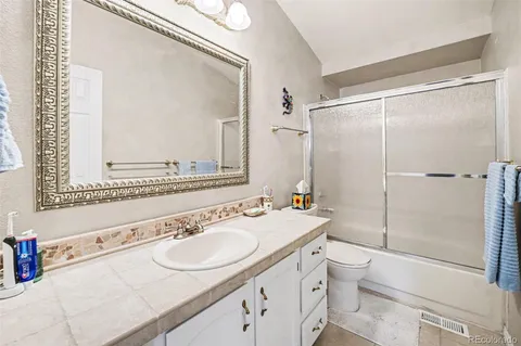 a bathroom with a sink toilet double vanity and shower