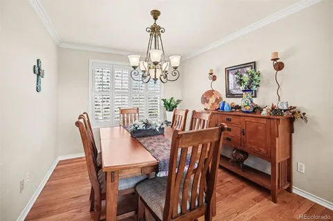a view of a dining room with furniture a chandelier and wooden floor