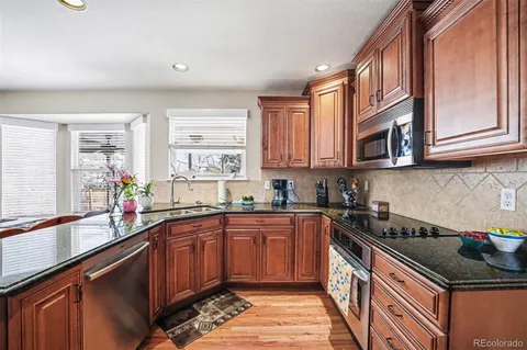 a kitchen with stainless steel appliances granite countertop a sink stove and cabinets