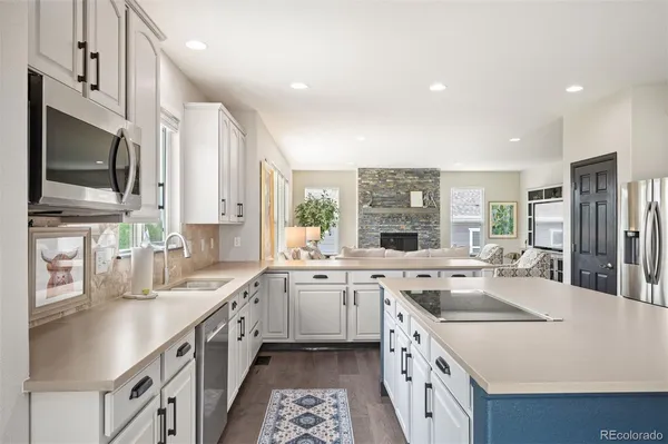 a kitchen with a sink stove top oven and refrigerator
