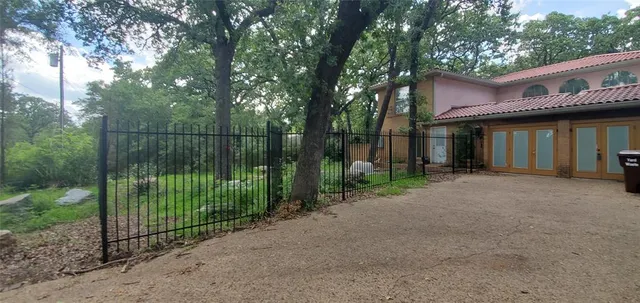 a view of a house with a small yard and a large tree