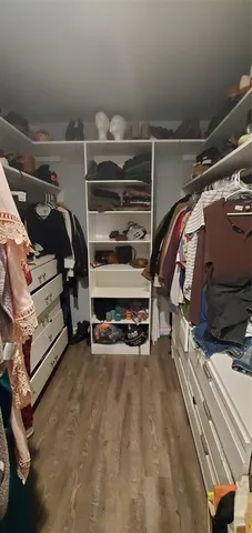 a view of walk in closet with clothes and shoes