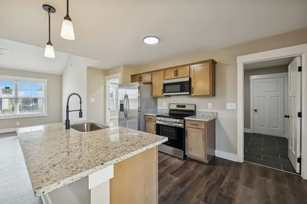 a kitchen with kitchen island a sink appliances and cabinets