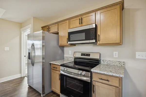 a kitchen with stainless steel appliances granite countertop a stove microwave and refrigerator