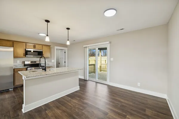 a large white kitchen with wooden floor